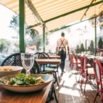 Outdoors summer terrace cafe with served table and waiter. If pests infest your business, Batzner Pest Control is here to help.